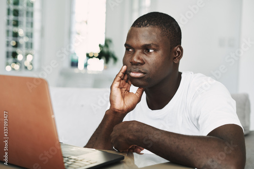 man of african appearance in front of a laptop
