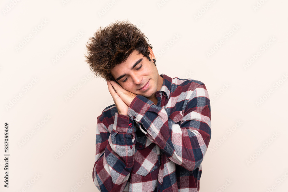 Young caucasian man making sleep gesture in dorable expression Young caucasian man making sleep gesture in dorable expression