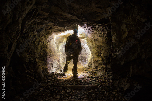 Underground abandoned platinum ore mine tunnel with miner photo