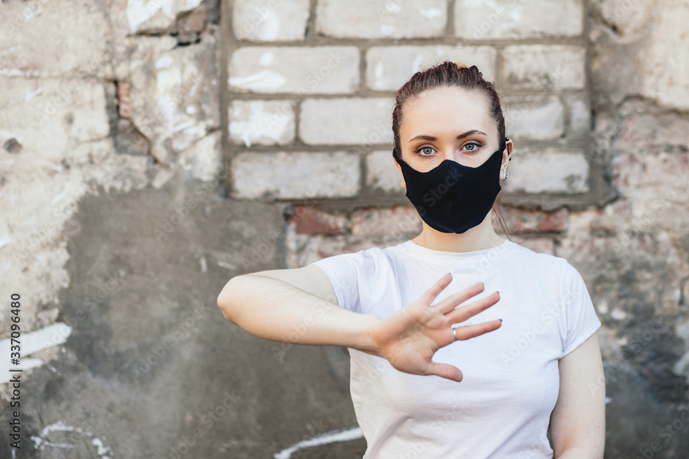 Obraz premium Woman with hand up in protective mask
