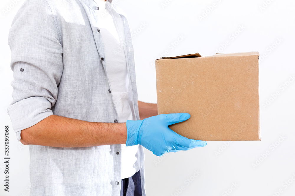 Delivery man holding cardboard boxes in medical rubber gloves and mask. copy space. Fast and free Delivery transport . Online shopping and Express delivery . Quarantine Delivery man holding cardboard boxes in medical rubber gloves and mask. copy space. Fast and free Delivery transport . Online shopping and Express delivery . Quarantine