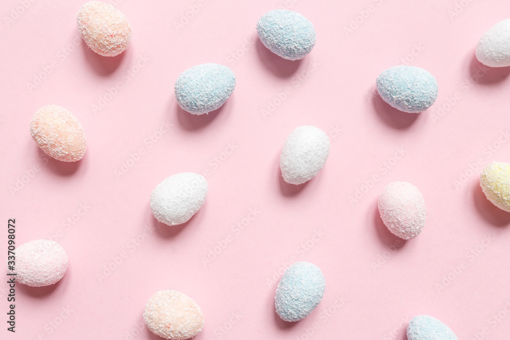 Obraz premium Easter flat lay background of colorful eggs on a pink background, Easter pattern top view with copy space.