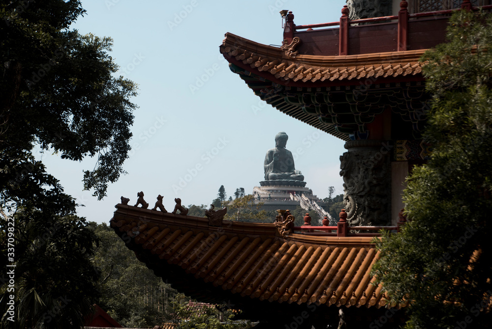 Fototapeta premium giant buddha statue through pagoda architecture