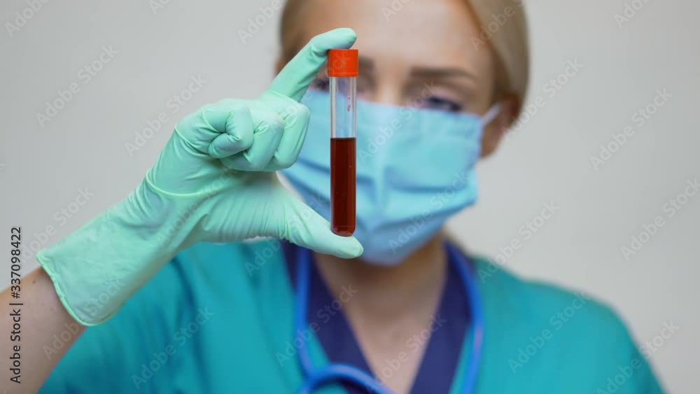 medical doctor nurse woman wearing protective mask and latex gloves - holding blood test tube medical doctor nurse woman wearing protective mask and latex gloves - holding blood test tube