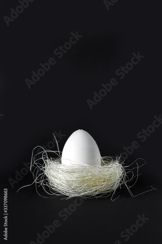 Easter. Nest with golden festive Easter eggs on a black background with copy space, Easter greetings card