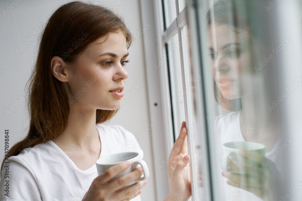 young woman looking through window
