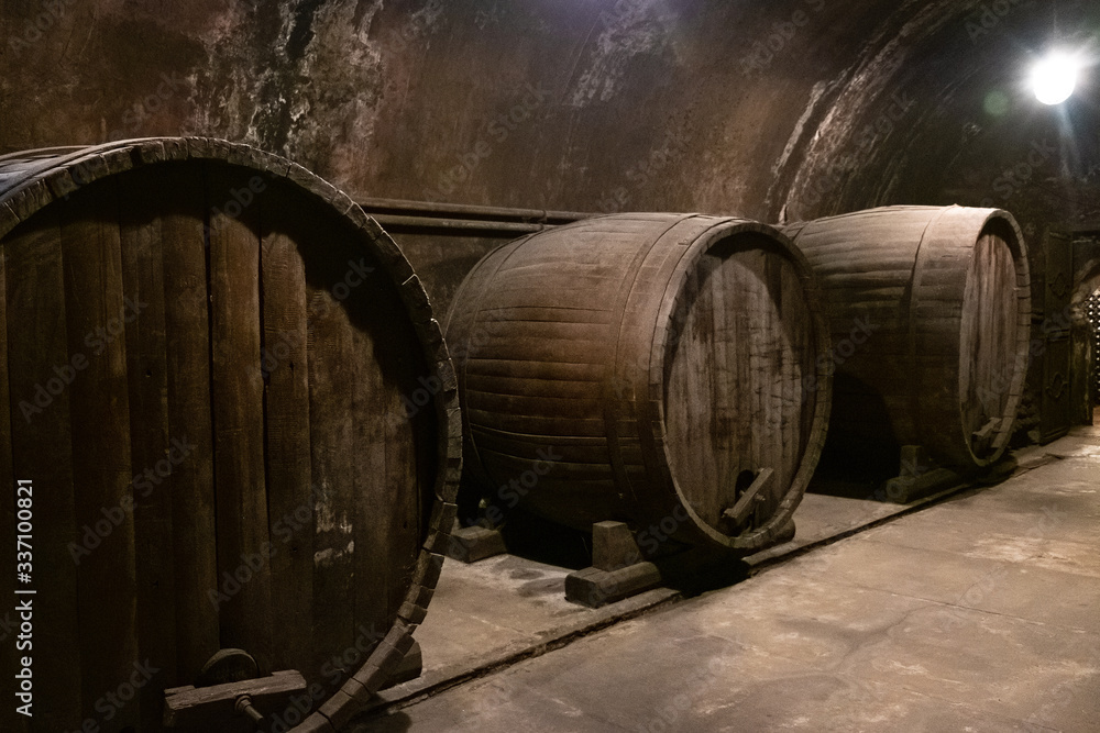 Large oak wine barrels stand in an old ancient cellar. Large oak wine barrels stand in an old ancient cellar.