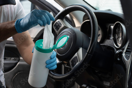 Canvastavla A bearded brown haired man wearing a baseball cap uses alcohol wipes to steriliz