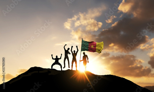 A group of people celebrate on a mountain top with Cameroon flag. 3D Render