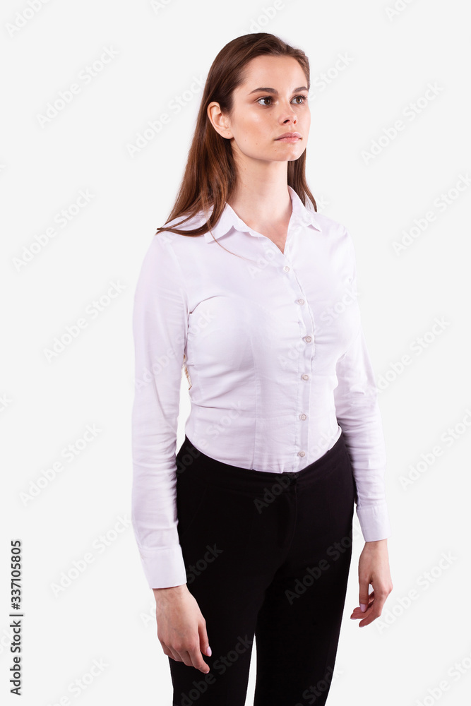Girl in casual wear stands half-sides and looks straight ahead. White background Girl in casual wear stands half-sides and looks straight ahead. White background