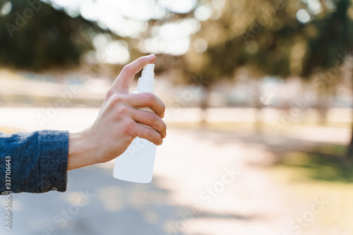 Man`s hand holds plastic bottle with antiseptic to protect from coronavirus covid 19. Isolated photo. © Rabizo Anatolii