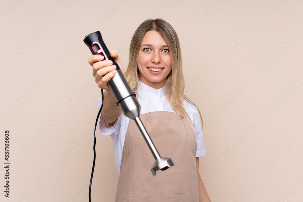 Young blonde woman using hand blender Young blonde woman using hand blender