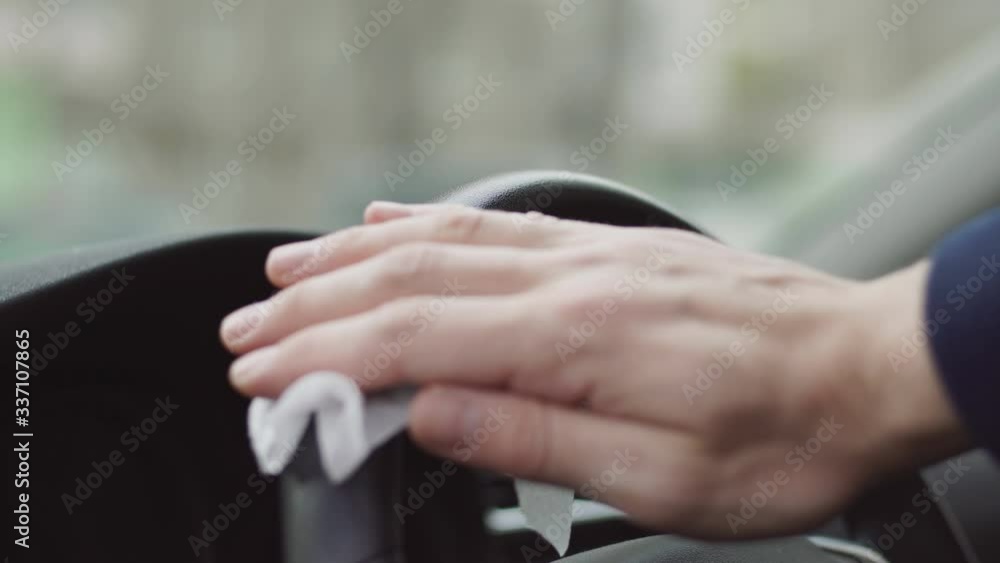 Driver using wet wipe for disinfecting car steering wheel against Novel coronavirus or Corona Virus Disease (Covid-19) Driver using wet wipe for disinfecting car steering wheel against Novel coronavirus or Corona Virus Disease (Covid-19)