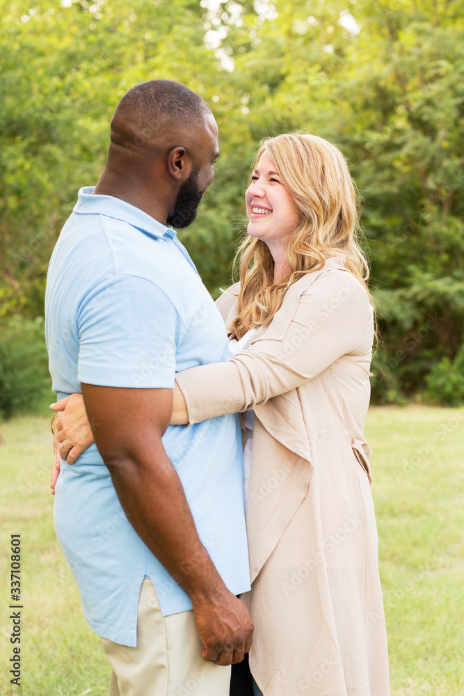 Loving mixed race couple hugging and laughing. Loving mixed race couple hugging and laughing.