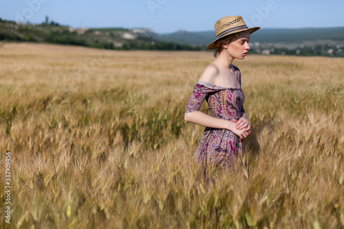 Beautiful fashionable blonde woman in a field of wheat