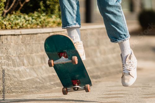 Skateboarding at city. Female, enjoyment. Hipster girl riding skate board. Ride, style. Extreme sport and emotions concept. Alternative lifestyle. Woman skateboarder skateboarding at city