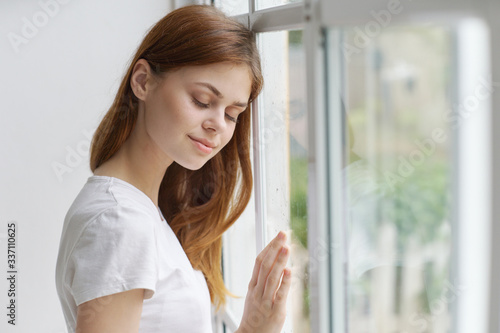 portrait of a young woman looking out window