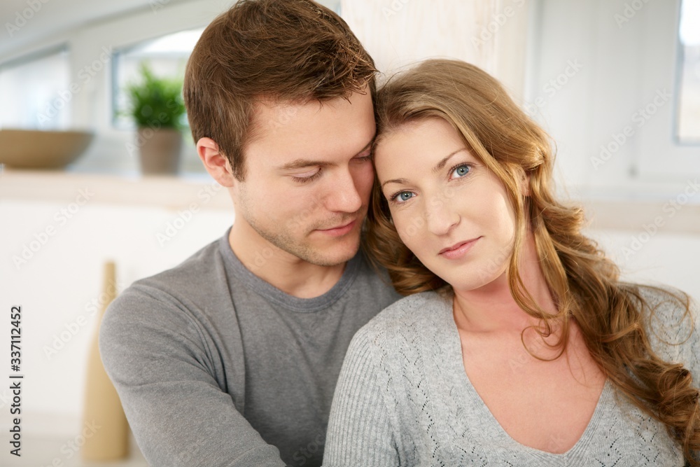 Portrait of young couple at home, looking at camera, smiling. Portrait of young couple at home, looking at camera, smiling.