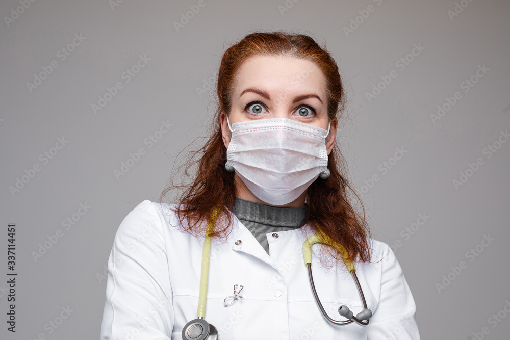 Portrait of caucasian female with short fair hair in white medical gown and special mask Portrait of caucasian female with short fair hair in white medical gown and special mask