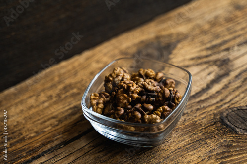 Walnut in a small plate on a vintage wooden table as a background. Walnuts is a healthy vegetarian protein nutritious food. Natural nuts snacks.