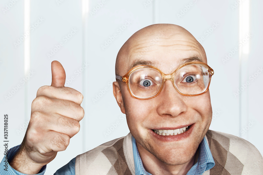 Portrait Bald man with glasses shows a thumb up and smiles Stock Photo ...