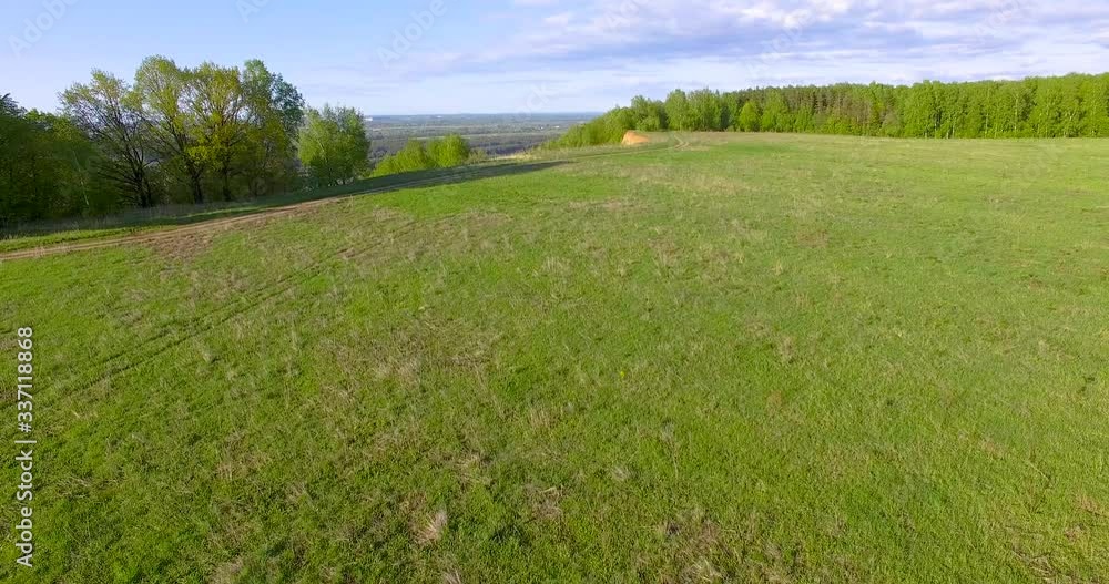flying forward at low altitude over a green spring field flying forward at low altitude over a green spring field