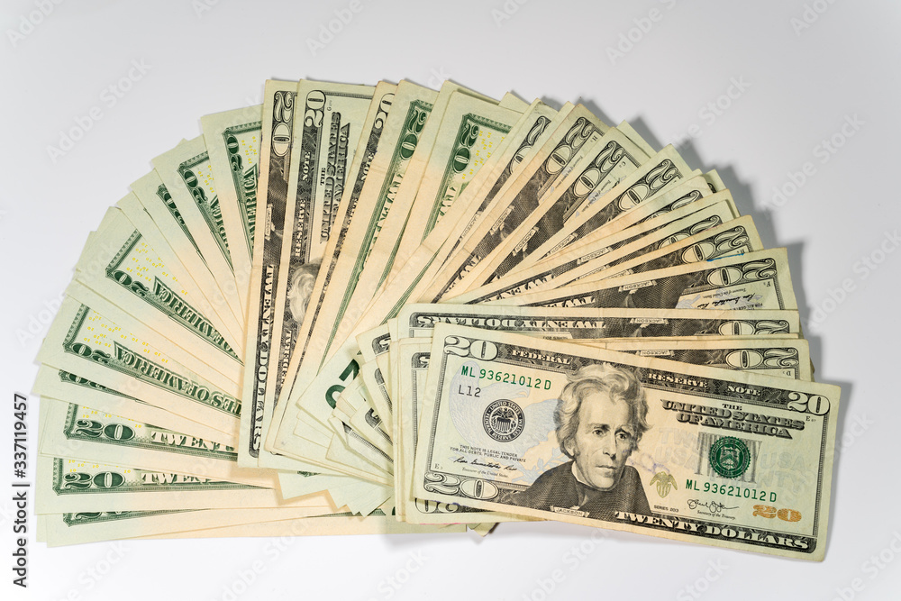 Thousands of US dollars laid out in a fan shape with 20 dollar bills against a white background Thousands of US dollars laid out in a fan shape with 20 dollar bills against a white background