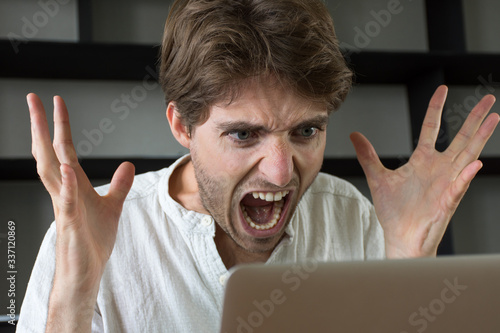 Homme furieux qui crie sur son ordinateur photo