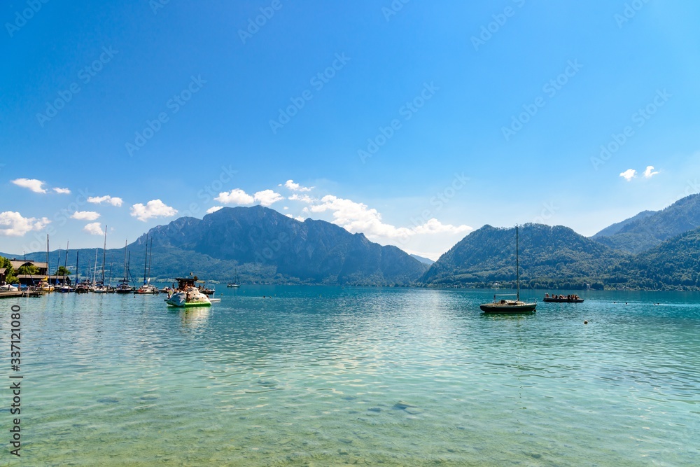 Beautiful view on Attersee lake im Salzkammergut, alps mountain, boat, sailboat in by Unterach. Upper Austria, nearby Salzburg.