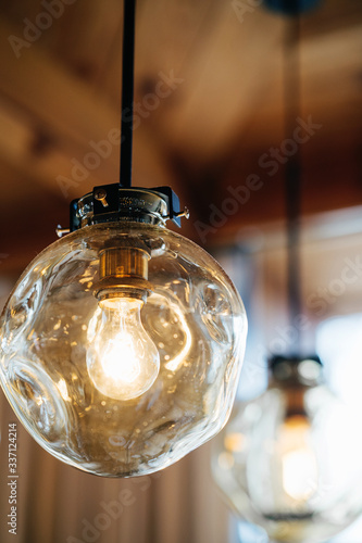 Loft-style luminaires in the interior of a modern cafe. Photo with blurred background.