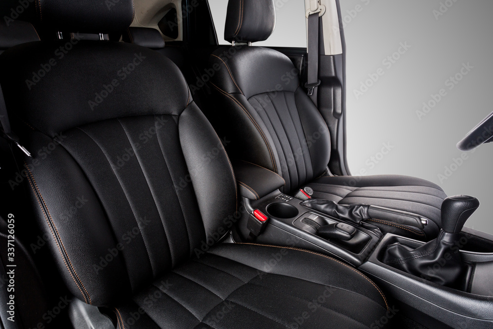 Naklejka premium the interior of the car is covered with handmade genuine leather. General plan of the front row of car seats. The control panel and levers are visible. High-quality stitching with gold threads