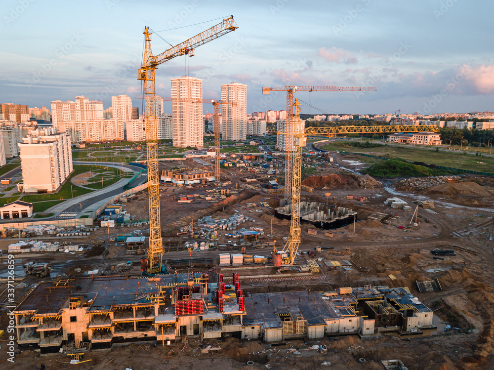 Aerial view of construction site of residential area buildings with cranes
