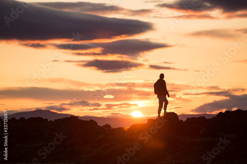 silhouette of a man on a rock at sunset  iceland