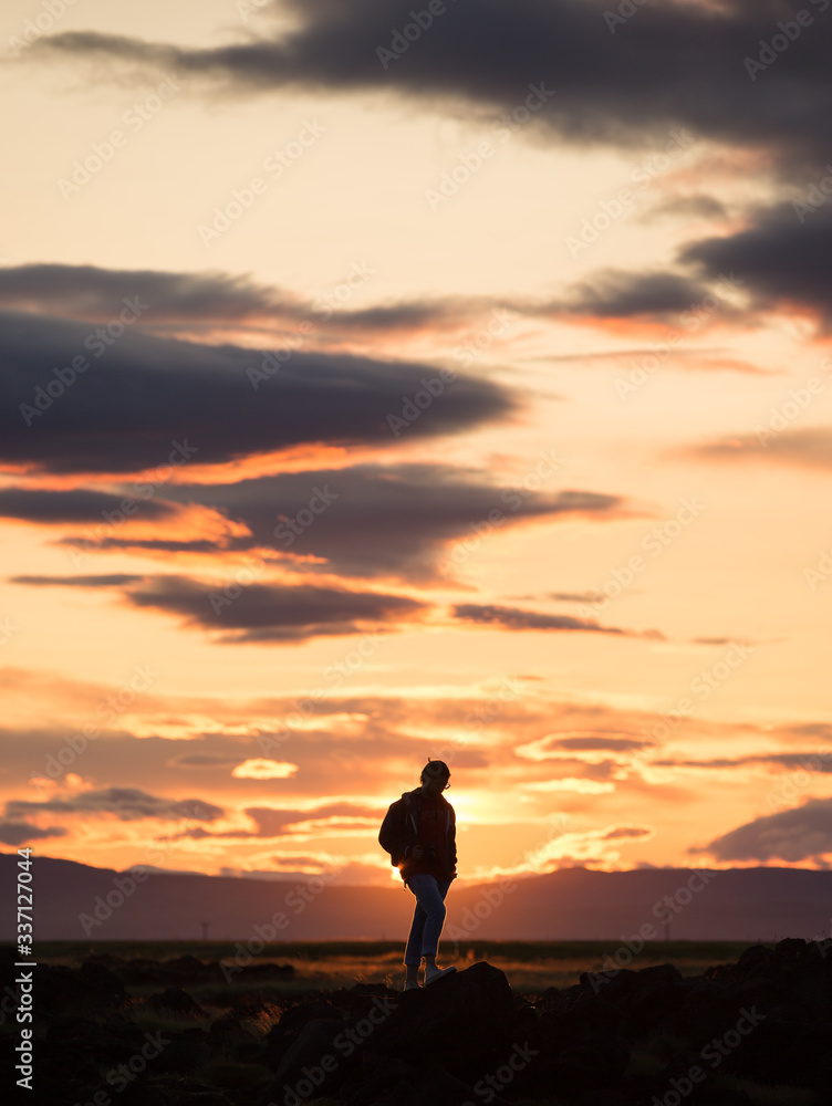 silhouette of a man on a rock at sunset, iceland