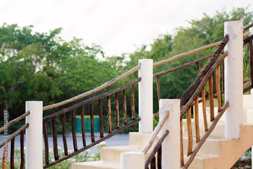 White staircase with wooden railing against the backdrop of the forest.