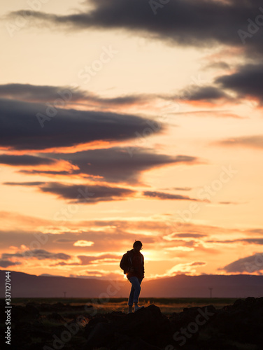 silhouette of a man on a rock at sunset  iceland
