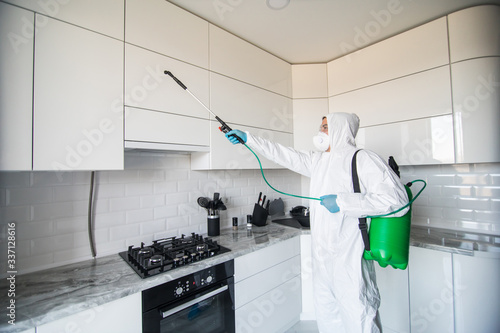 Quadro em tela Disinfector in a protective suit conducts disinfection in contaminated area