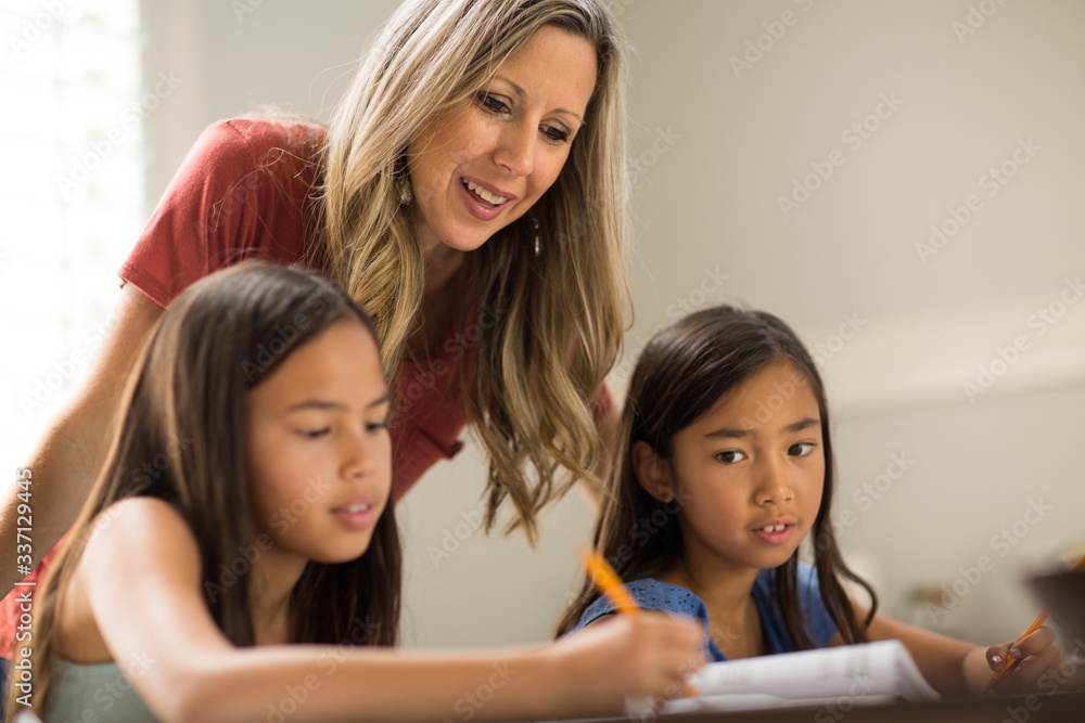 Mother Helping Her Daughters With Their Homework Mother Helping Her Daughters With Their Homework