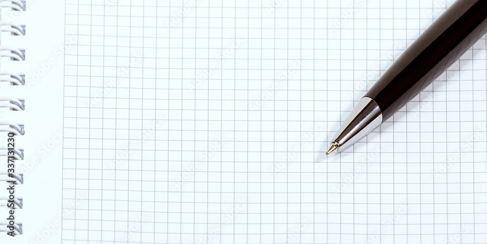 Black pen and notebook with a spiral Black pen and notebook with a spiral