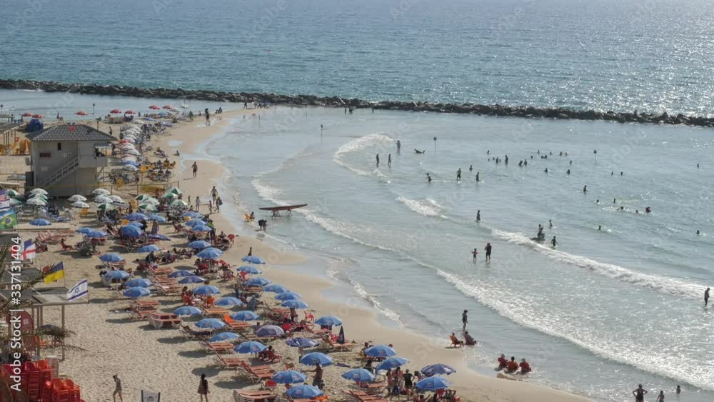 tel aviv Active sunny day with people on the beach People sunbathing on crowded beach, waves rolling onto seashore, sunny summer. tel aviv Active sunny day with people on the beach People sunbathing on crowded beach, waves rolling onto seashore, sunny summer.