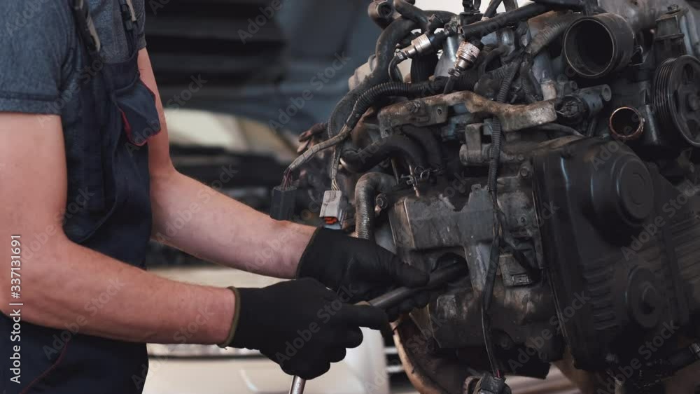 Person repaires engine of car. Man works in service center. Worker removed engine from car. Person repaires engine of car. Man works in service center. Worker removed engine from car.