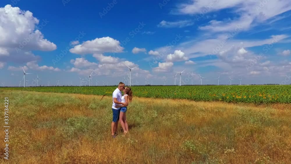 Young couple walks on a cliff beautiful nature wind farm Young couple walks on a cliff beautiful nature wind farm