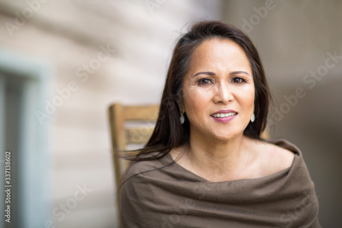 Happy mature Asian woman laughing and smiling.