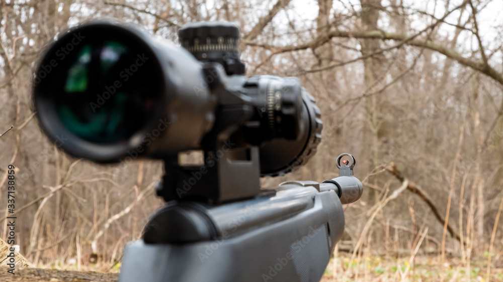 rifle with scope on the background of the forest rifle with scope on the background of the forest