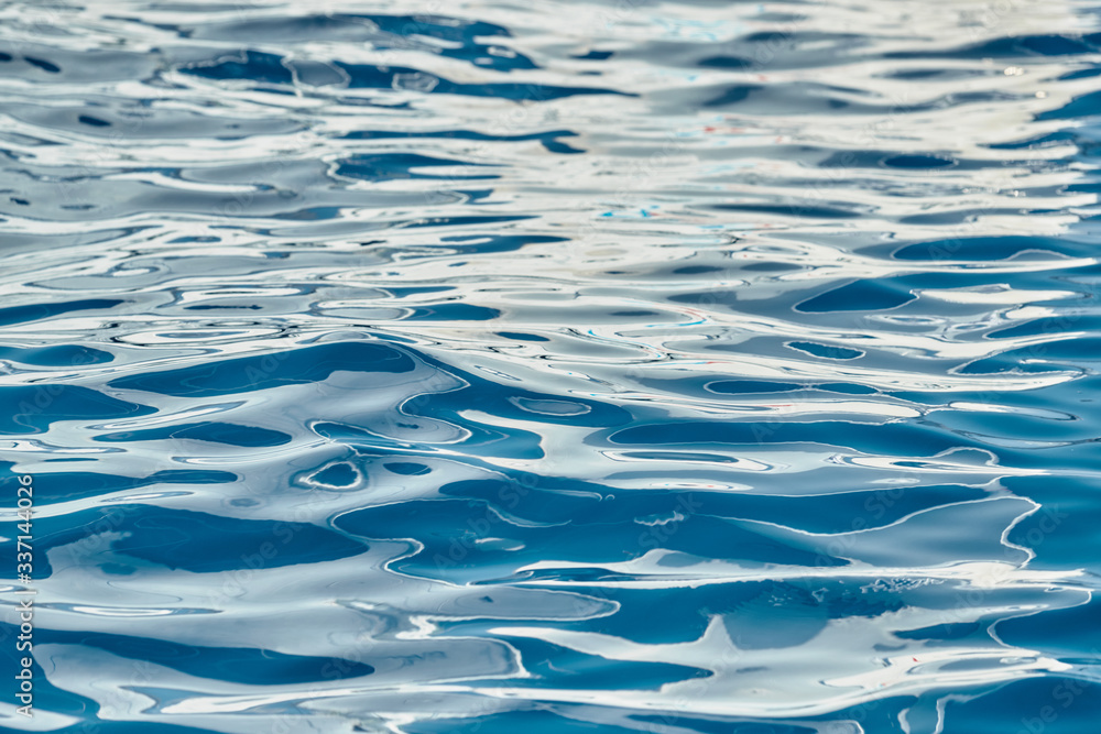 Is reflection of white sail on water, interesting texture, smooth lines of water, a sail regatta, Bright colors