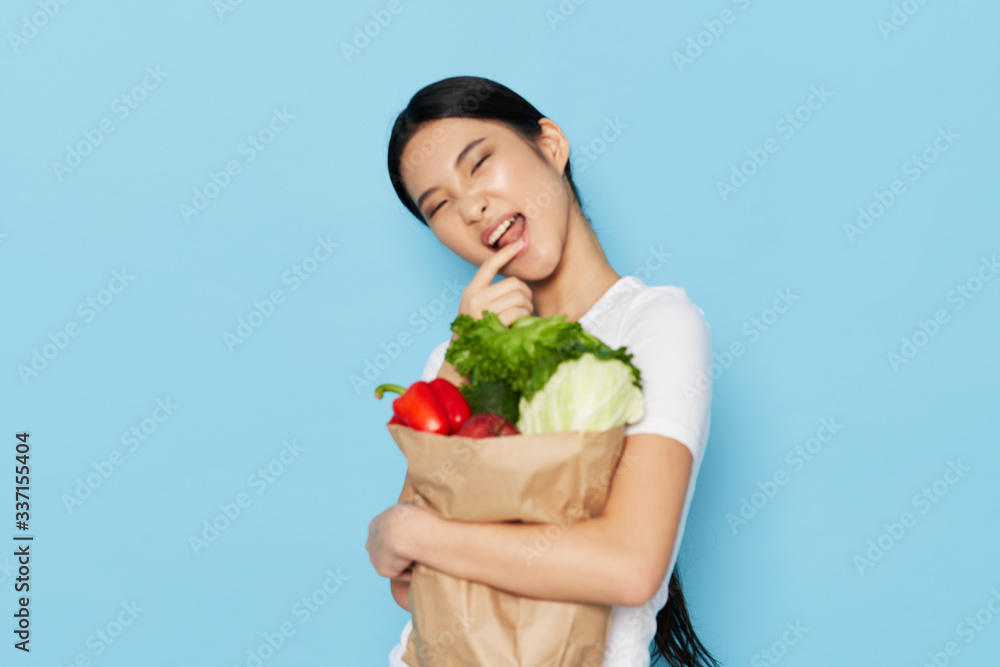 young woman holding a shopping bag full of groceries
