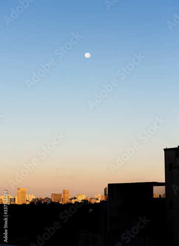 Dawn in the city of Sao Paulo in the Bairro Jardins region with a full moon