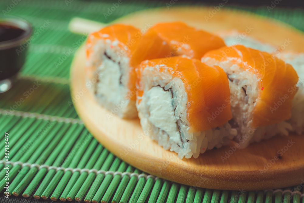 Close up of tasty sushi rolls on cutting board. Close up of tasty sushi rolls on cutting board.