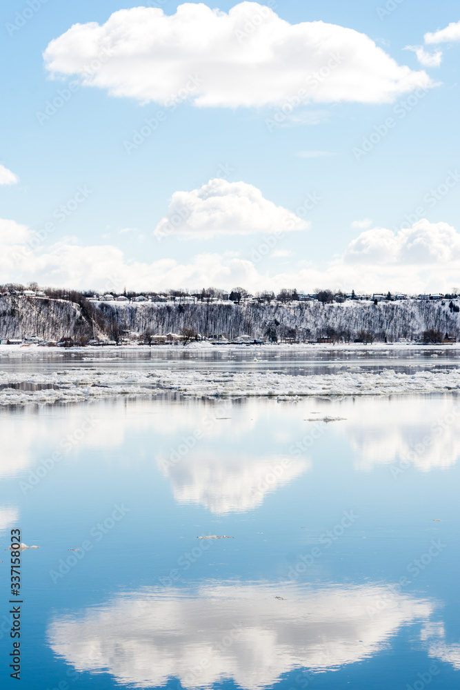 A clouds reflection in the river with floating ice