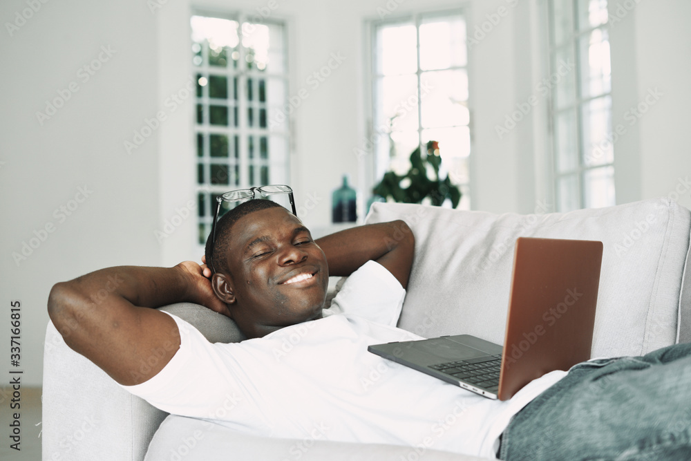 A man of African appearance at home in front of a laptop A man of African appearance at home in front of a laptop